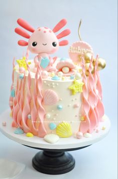 a pink and white cake with an octopus on top