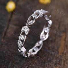 a wedding ring with diamonds on top of a wooden table and lemons in the background