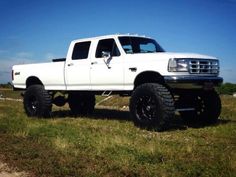 a white truck parked on top of a grass covered field