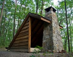 a small cabin in the woods with a chimney