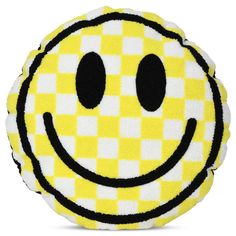 a yellow and white checkered smiley face pillow with black eyes on the front side