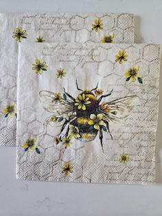 two napkins with bees and flowers on them