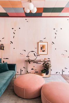 a living room with pink and blue couches, coffee table and art work on the wall