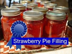 several jars of strawberry pie filling sitting on a table