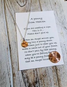 a penny necklace with a poem written on it and two coins hanging from the back