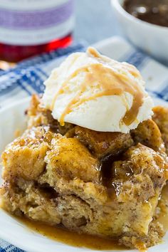 a close up of a plate of food with ice cream on top and syrup in the background