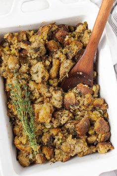 a casserole dish with stuffing and a wooden spoon