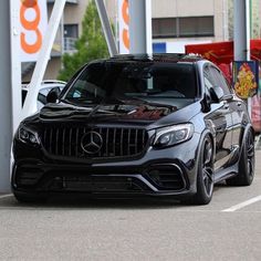 a black mercedes glc parked in front of a gas station with an orange sign