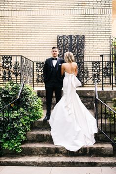 the bride and groom are walking down the stairs