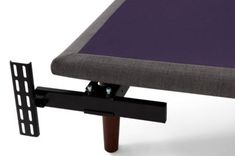 a bed frame with a purple mattress on it and a black metal holder for the headboard