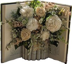 an open book with flowers on it