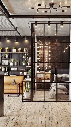 an industrial style living room with wood floors and glass doors that lead into the bedroom