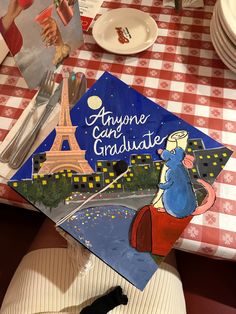 a graduation cap with an image of the eiffel tower on it sitting on top of a table