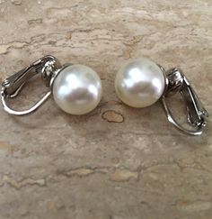 These Classic Pearl Clip on Earrings are so elegant on! I make these using 10mm Swarovski Pearls in your choice of either Cream Ivory or White pearls with finishes in Gold or Silver tone clip settings. Available in some other color choices...just ask! Choose the color and finish from the Drop-down menu. Perfect Bridal Wedding jewelry with clip on backs. These are also available in Pierced styles and quantities for Bridesmaids! These photos show: Silver with Cream Ivory pearls and Gold with White Classic White Gold Clip-on Earrings For Formal Occasions, Classic White Gold Clip-on Earrings, Classic White Clip-on Pearl Earrings, White Pearl Clip-on Earrings For Formal Occasions, White Clip-on Pearl Earrings For Formal Occasions, Elegant White Earrings With Screw Back, Classic White Gold Clip-on Earrings For Anniversary, Classic White Gold Clip-on Jewelry, Formal Sterling Silver Clip-on Bridal Earrings