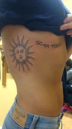 a woman with a sun tattoo on her stomach and the words scar tissue written in cursive ink