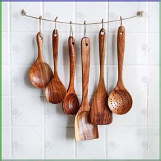 wooden utensils hanging from a line on a tiled wall