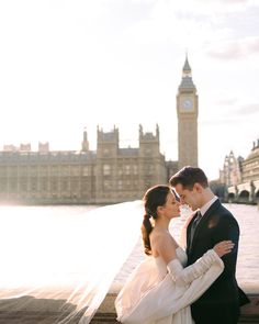 a bride and groom standing in front of the big ben clock tower