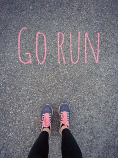 someone's feet standing in front of the word go run written with pink chalk