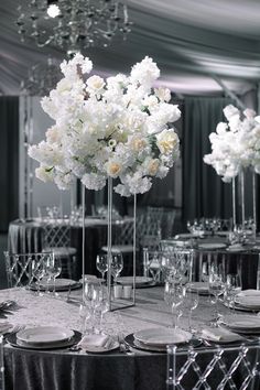 the centerpieces are filled with white flowers and place settings