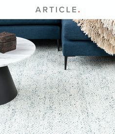 a living room with a blue couch and coffee table in front of an article on carpeting