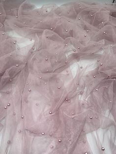 Pearl Tulle fabric This beautiful dusty pink tulle fabric is adorned with pearls, making it a perfect choice for any bridal dress or special occasion. The fabric is 58 inches wide (147cm) and suitable for a range of apparel projects, including dresses, curtains, wedding dresses, drapery, costumes, kimonos, and more. Crafted from high-quality tulle material, this fabric is both durable and elegant. The pearls add a touch of glamour and sophistication, making it a perfect choice for any bride who Pink Tulle Fabric, Tulle Material, Beaded Tulle, Pink Tulle, Tulle Fabric, Pink Pearl, Bridal Dress, Wedding Basket, Dusty Pink