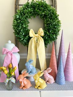 a table topped with different colored stuffed animals next to a wreath