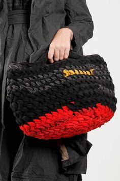 a person holding a black and red bag