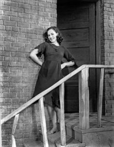 an old photo of a woman standing on the steps