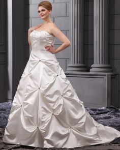 a woman in a white wedding dress posing for the camera