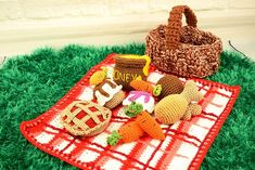 there is a picnic blanket with food on it and a basket in the grass next to it