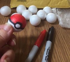 a person is holding a pokeball in front of some other items on a table