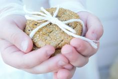 a person holding a piece of food in their hands with a string tied around it