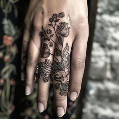 a woman's hand with a flower tattoo on it