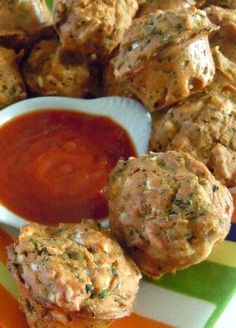 some meatballs and sauce on a plate with a striped table cloth in the background