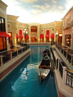 two gondola boats are docked in the middle of a shopping mall's pool