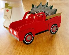 a red toy truck with trees in the back