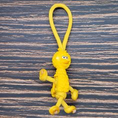 a yellow keychain with a cartoon character on it's side hanging from a hook