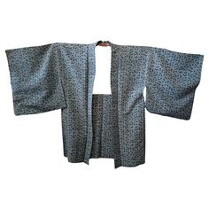 This is a silk jacket which was made in Japan. It was made in Showa era around 1980s. The haori is a traditional Japanese hip- or thigh-length jacket worn over a kimono. Resembling a shortened kimono with no overlapping front panels (okumi), the haori typically features a thinner collar than that of a kimono, and is sewn with the addition of two thin, triangular panels at either side seam. The haori is usually tied at the front with two short cords, known as haori himo, which attach to small loo Japanese Jacket, Haori Jacket, Showa Era, Grey Flowers, Japanese Silk, Silk Jacket, White Silk, Red Jacket, Traditional Japanese