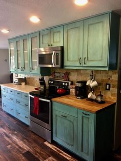 a kitchen with wooden floors and green cabinets