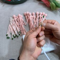 a person is making pink and green candles