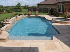 a small pool in the middle of a backyard with patio furniture and landscaping around it