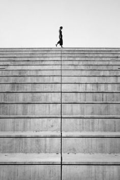 black and white photograph of a person walking up stairs