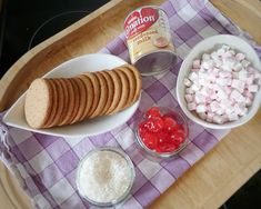 some food is sitting on a table with other foods in bowls and spoons next to it