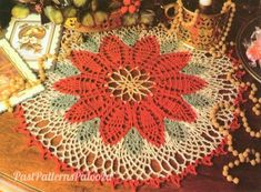 a crocheted doily with poinsettis and other items on the table