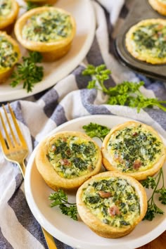 mini quiches filled with spinach and cheese on a plate next to a fork