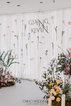 the wedding backdrop is decorated with flowers and greenery