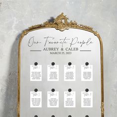 a gold framed wedding seating chart with black dots and calligraphy on the back side