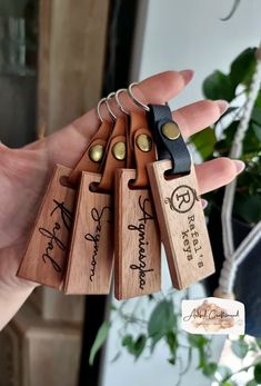 four wooden keychains with writing on them in the palm of someone's hand