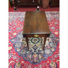 a wooden table sitting on top of a red rug