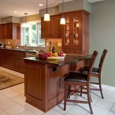 a kitchen filled with lots of wooden cabinets and counter top space next to a dining room table